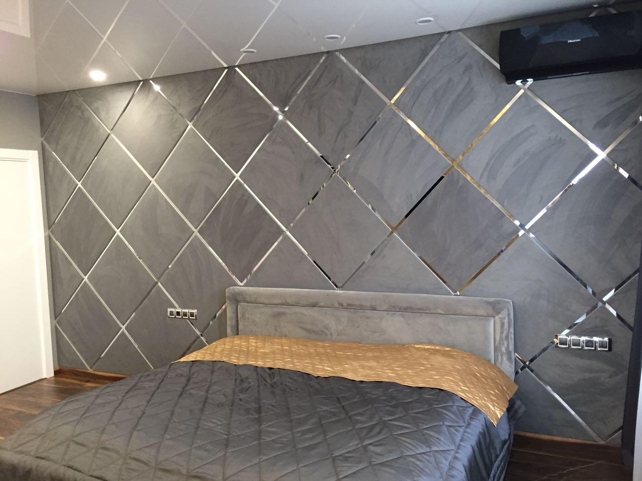 Проект стены спальни с диагональным расположением тканевых монохромных квадратных плит с хромированным обрамлением.